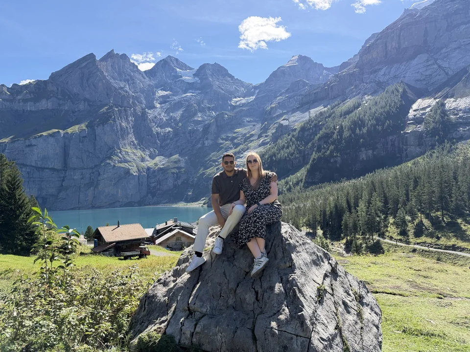 Mohamed und Laura von RosenVows sitzen gemeinsam auf einem Felsen oberhalb eines Bergsees.